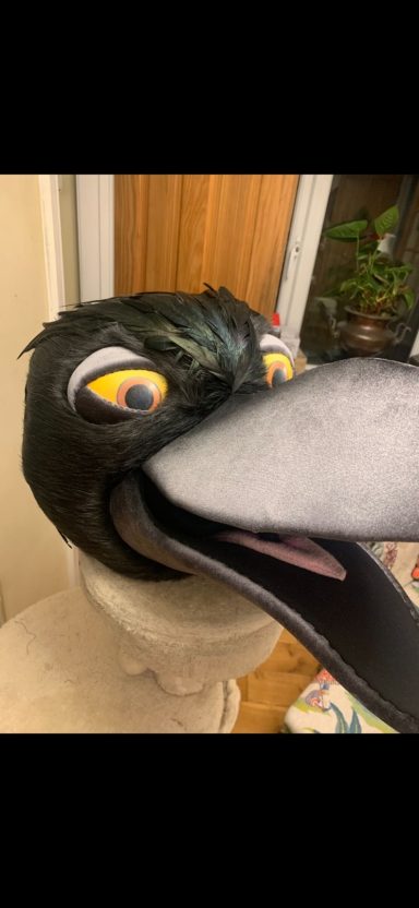 A large, cartoonish bird mask with vivid colours and exaggerated features.