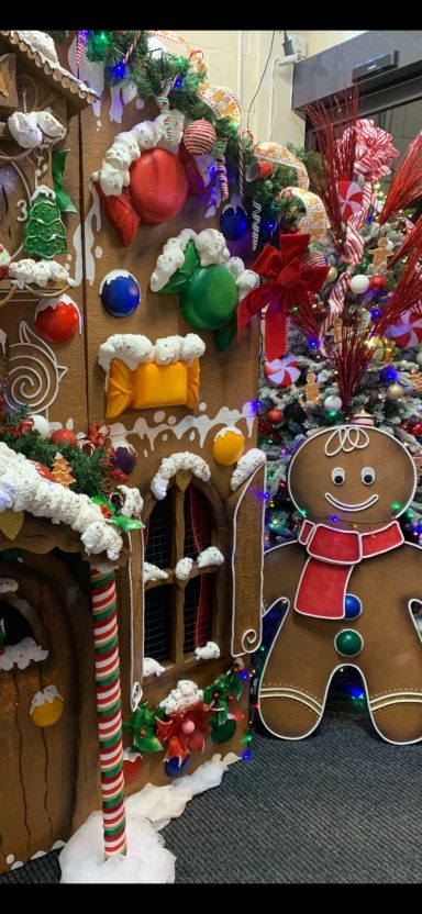 A festive display featuring a gingerbread house and a gingerbread man surrounded by decorations.