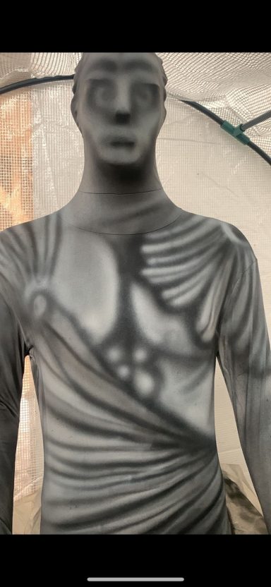 Statue of a male figure draped in fabric with detailed musculature.