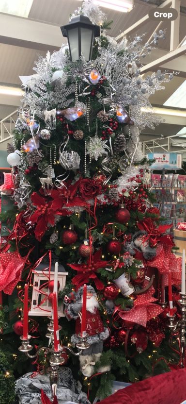 Christmas tree adorned with red ribbons, silver decorations, and lights.