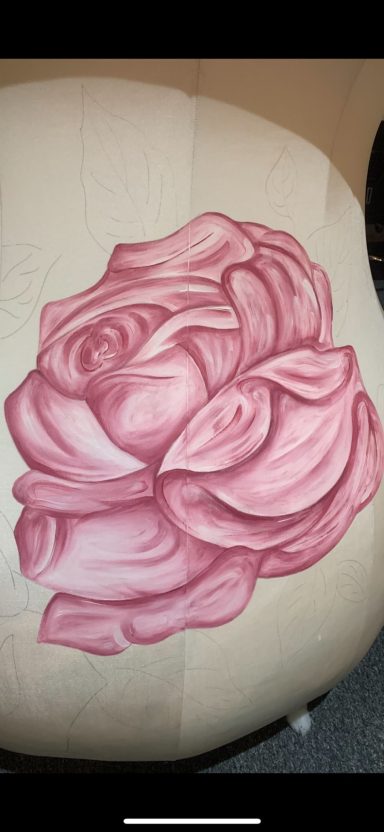 Pink rose with intricate petals, resting on a light background.