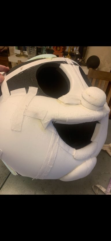 A large, smiling white cartoon character's head with a circular shape and hollow eyes.