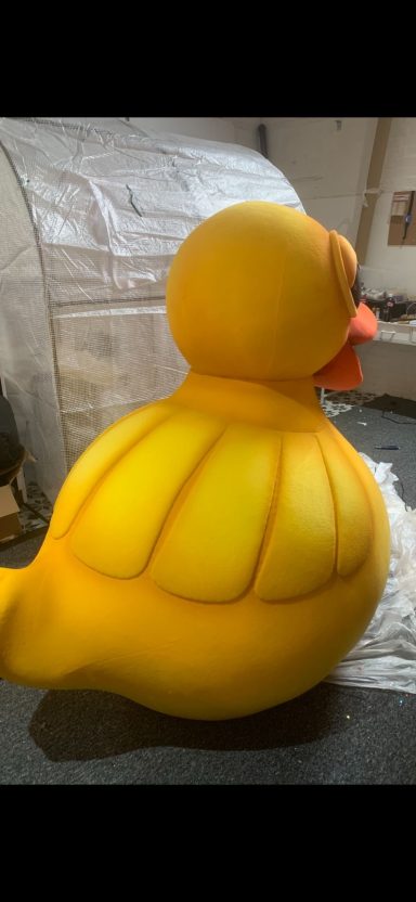A large, bright yellow rubber duck with a round shape and orange beak.