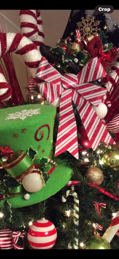Decorated Christmas tree with red and white bows, ornaments, and festive greenery.