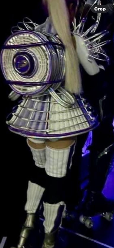 A fashion design featuring a spiralled backpack and a detailed, ornate outfit.