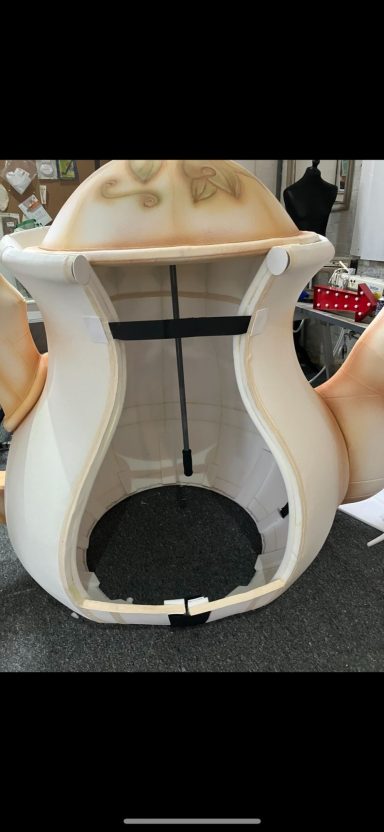 A partially assembled teapot with a curved design and open cavity.