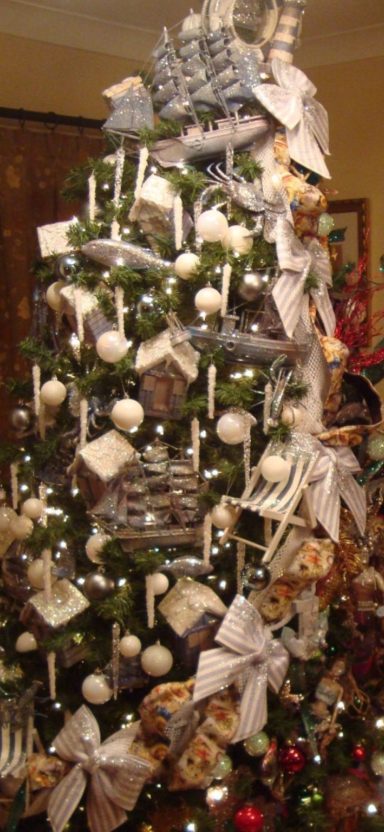 A festively decorated Christmas tree with ornaments, ribbons, and candles.