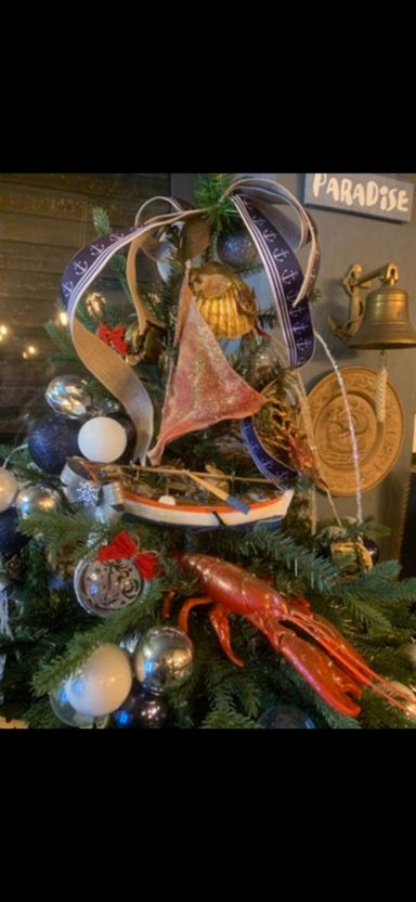 Decorated Christmas tree with various ornaments, ribbons, and a star on top.