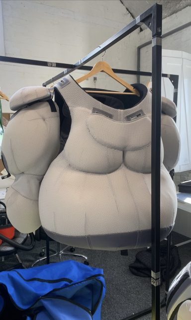 A padded safety vest hanging on a garment rack.