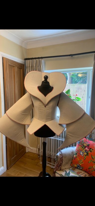 A tailored cream-coloured jacket with a heart-shaped collar on a mannequin.