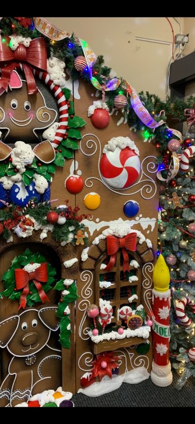 Decorated gingerbread house with candy accents and festive holiday decorations.
