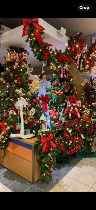 Festively decorated scene with green garlands, red bows, and Christmas ornaments.
